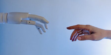Eine Roboter Hand trifft auf eine Menschen Hand Eine Roboter Hand trifft auf eine Menschen Hand