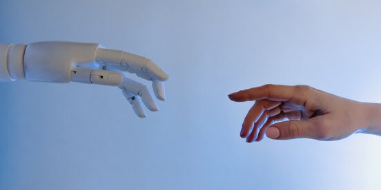 Eine Roboter Hand trifft auf eine Menschen Hand Eine Roboter Hand trifft auf eine Menschen Hand