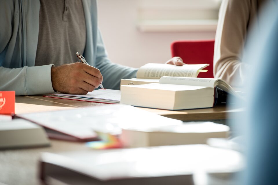 Eine Person schreibt etwas auf ein Blattpapier Eine Person schreibt etwas auf ein Blattpapier