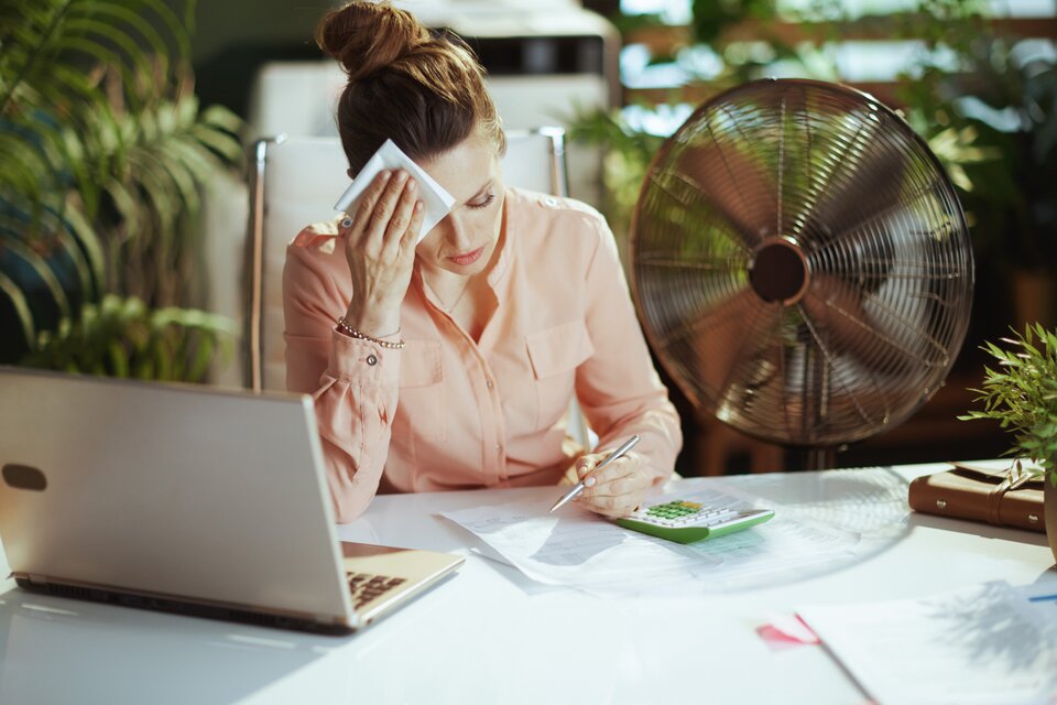 Eine Frau schwitzt am Arbeitsplatz Eine Frau schwitzt am Arbeitsplatz