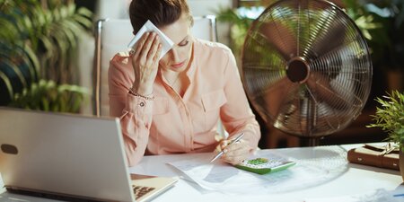Eine Frau schwitzt am Arbeitsplatz