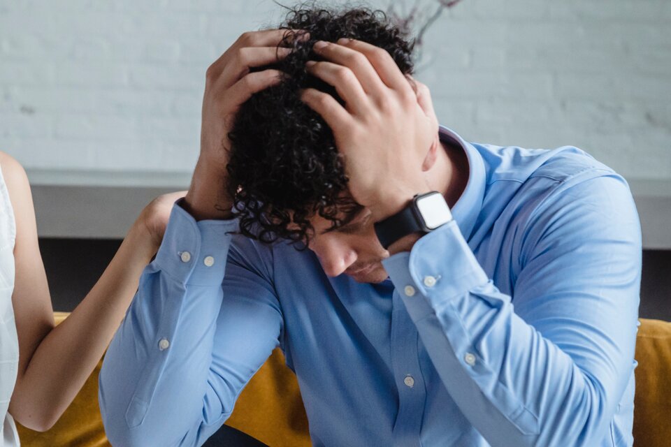Mann ist überlastet und hält seine Hände an den Kopf Mann ist überlastet und hält seine Hände an den Kopf