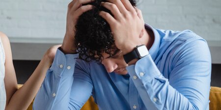 Mann ist überlastet und hält seine Hände an den Kopf Mann ist überlastet und hält seine Hände an den Kopf