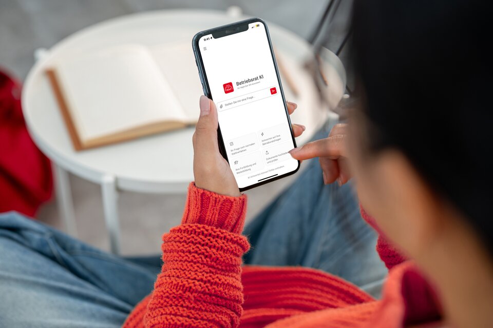 Frau hält Handy mit KI-Tool in der Hand