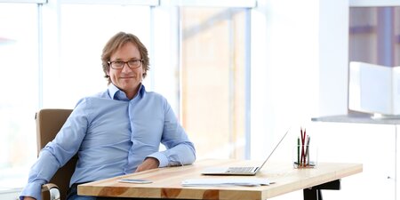Betriebsratsmitglied sitzt am Schreibtisch im Betriebsratsbüro Betriebsratsmitglied sitzt am Schreibtisch im Betriebsratsbüro