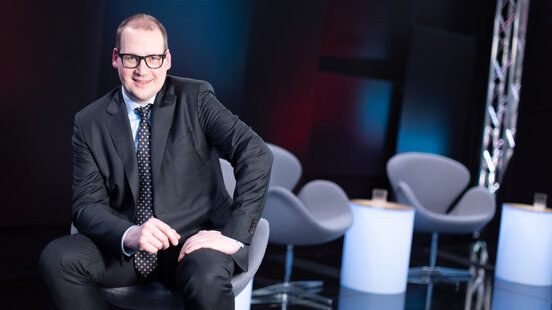 Mann sitzt auf einen Stuhl und besucht einen W.A.F. Talk 