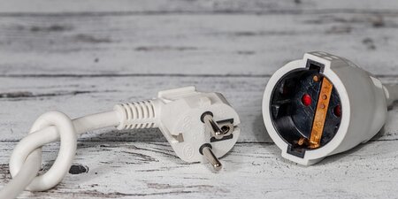 Ein Ladekabel und daneben liegt ein Verlängerungskabel Ein Ladekabel und daneben liegt ein Verlängerungskabel
