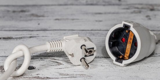 Ein Ladekabel und daneben liegt ein Verlängerungskabel
