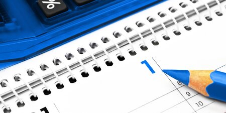 Ein Kalender auf dem ein blauer Stift liegt Ein Kalender auf dem ein blauer Stift liegt