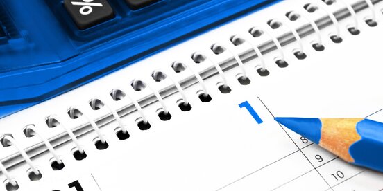 Ein Kalender auf dem ein blauer Stift liegt