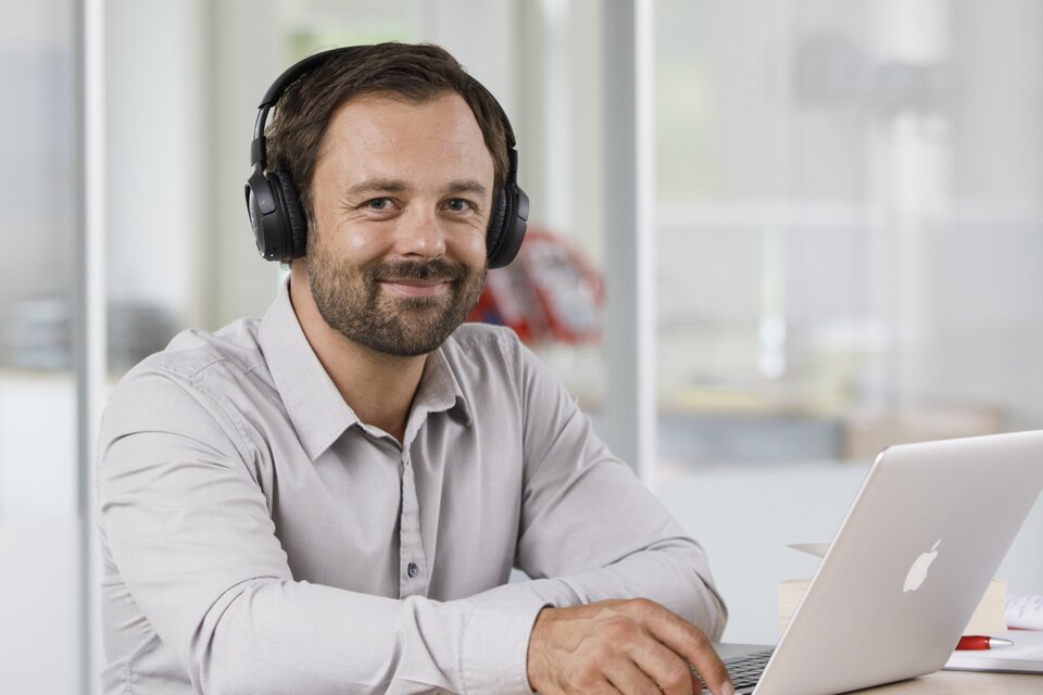 Ein Mann sitzt vor einem Laptop und arbeitet
