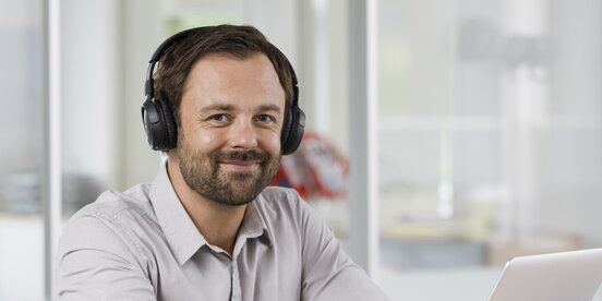 Ein Mann sitzt vor einem Laptop und arbeitet