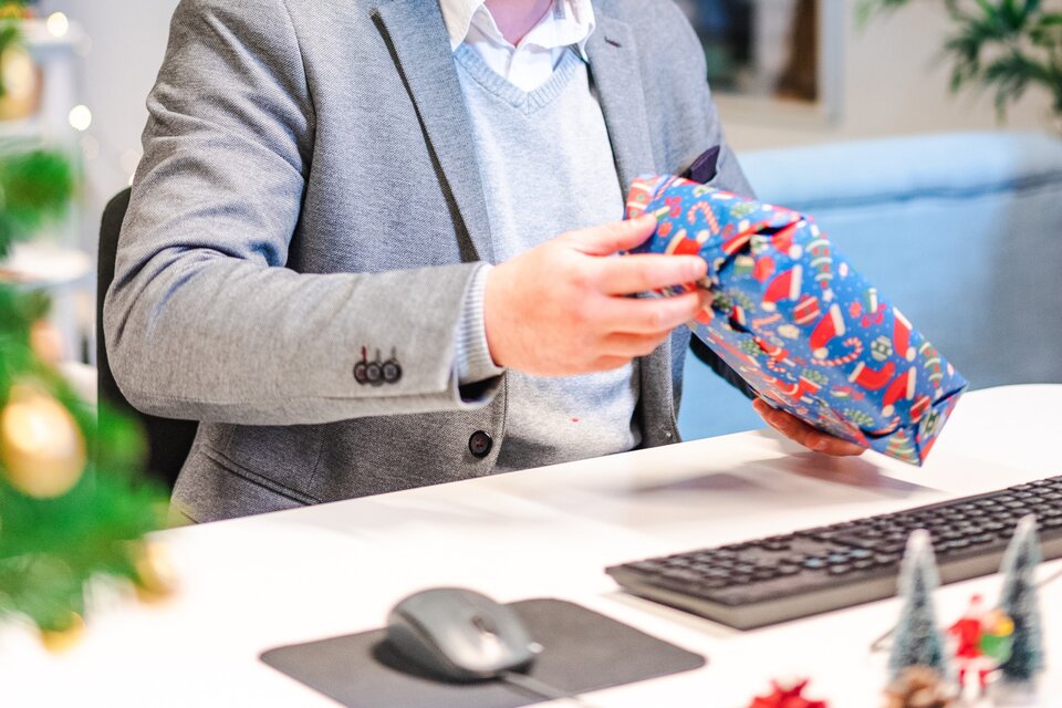 Ein Mann öffnet ein Weihnachtspaket Ein Mann öffnet ein Weihnachtspaket
