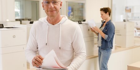 Ein Mann hat gedrucktes Papier in der Hand Ein Mann hat gedrucktes Papier in der Hand