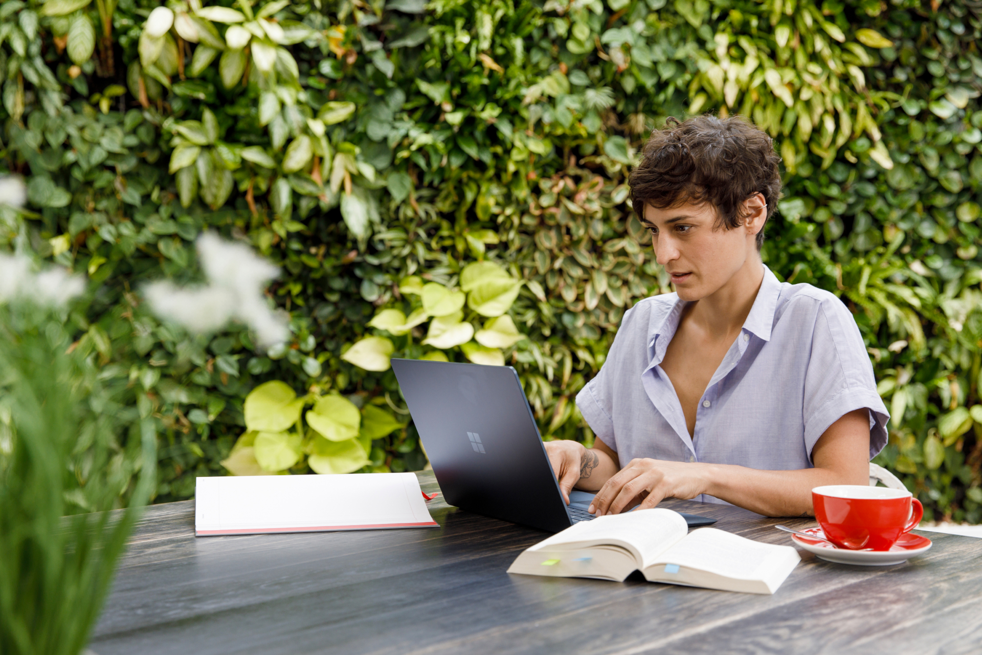Person informiert sich draußen um grünen an ihrem Laptop über den Gleichbehandlungsgrundsatz
