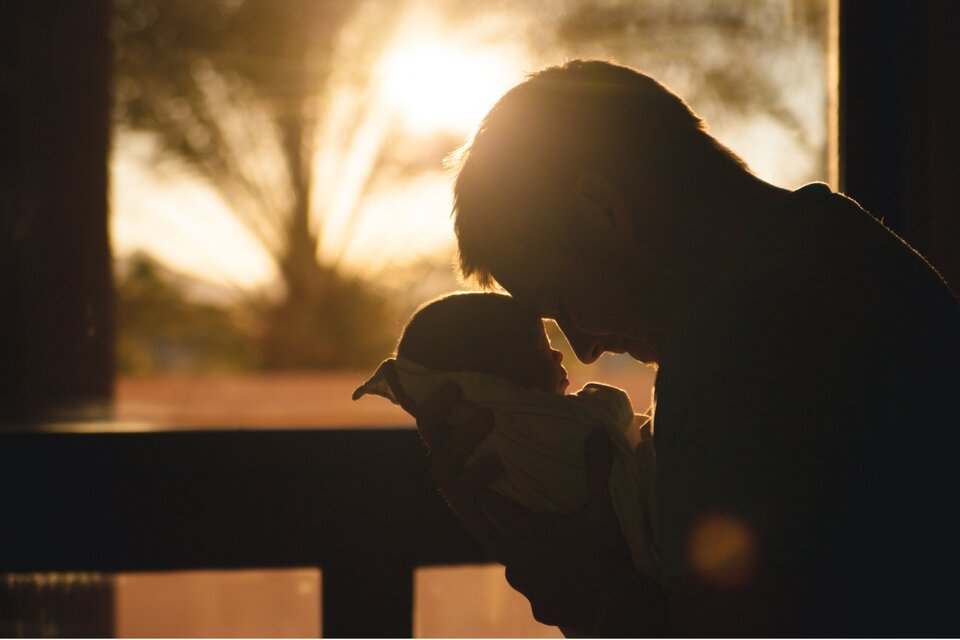 Ein Mann hält sein Baby in den Armen