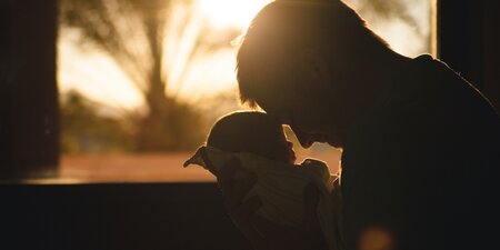 Ein Mann hält sein Baby in den Armen Ein Mann hält sein Baby in den Armen