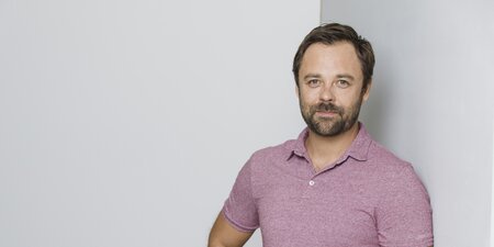 Ein Betriebsrat steht vor einer grauen Wand Ein Betriebsrat steht vor einer grauen Wand
