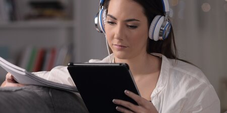 Eine Frau sitzt vor dem Tablet und führt das BEM durch Eine Frau sitzt vor dem Tablet und führt das BEM durch