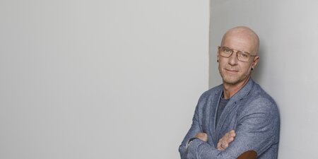 Ein Mann steht mit verschränkten Armen da