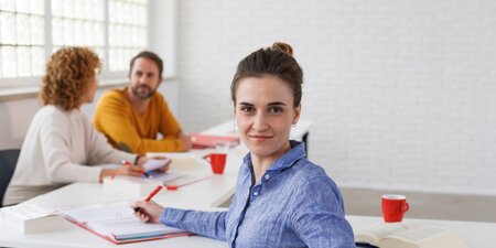 Eine Frau schreibt etwas auf ein Blattpapier Eine Frau schreibt etwas auf ein Blattpapier