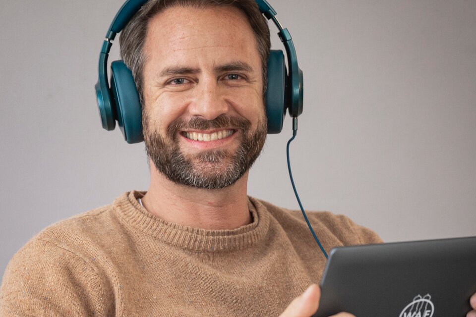 Ein Mann schaut in die Kamera und trägt ein Headset Ein Mann schaut in die Kamera und trägt ein Headset