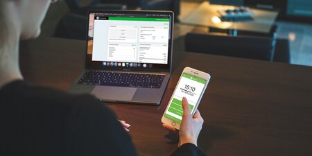 Eine Frau loggt sich am Handy in die Arbeitszeiterfassung ein