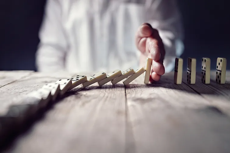 Hand stoppt fallende Dominos Hand stoppt fallende Dominos