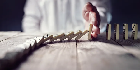 Hand stoppt fallende Dominos Hand stoppt fallende Dominos