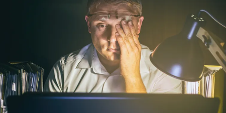 Mann sitzt spät abends verzweifelt vor seinem Laptop im Arbeitszimmer Mann sitzt spät abends verzweifelt vor seinem Laptop im Arbeitszimmer