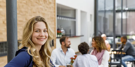 Person sitzt mit einem Café in der Küche, da sie Teilzeit hat.
