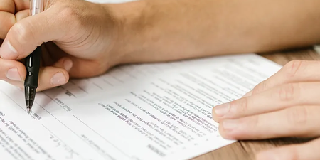 Eine Person unterschreibt die Beschlussfassung des Betriebsrats Eine Person unterschreibt die Beschlussfassung des Betriebsrats