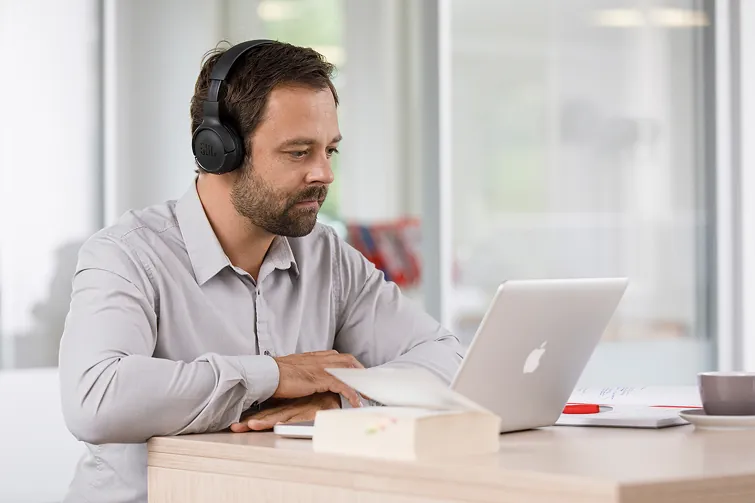 Mann sitzt vor dem Laptop und ist digitalisiert.