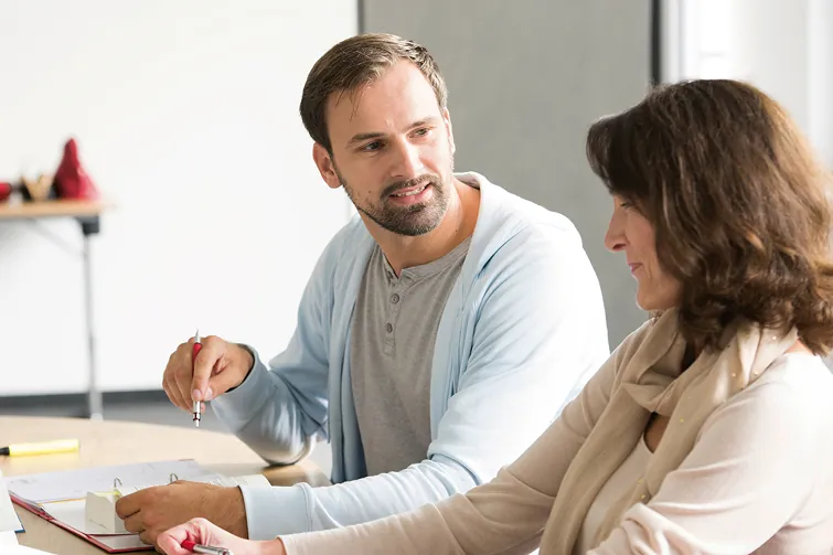 Ein Mann erklärt einer Frau das Betriebliches Eingliederungsmanagement Ein Mann erklärt einer Frau das Betriebliches Eingliederungsmanagement