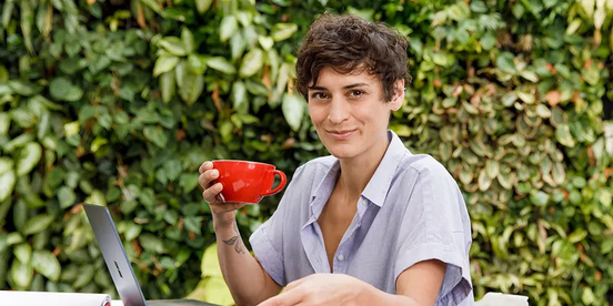 Person sitzt mit ihrem Kaffee draußen Person sitzt mit ihrem Kaffee draußen