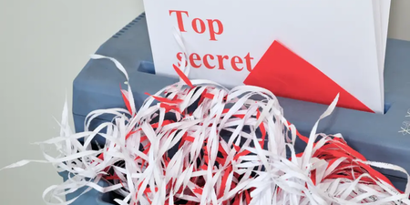 Dokument mit Aufschrift ‚Top Secret‘ in einem Aktenvernichter – Symbol für die Vernichtung verspäteter Briefwahlumschläge bei der Betriebsratswahl. Dokument mit Aufschrift ‚Top Secret‘ in einem Aktenvernichter – Symbol für die Vernichtung verspäteter Briefwahlumschläge bei der Betriebsratswahl.