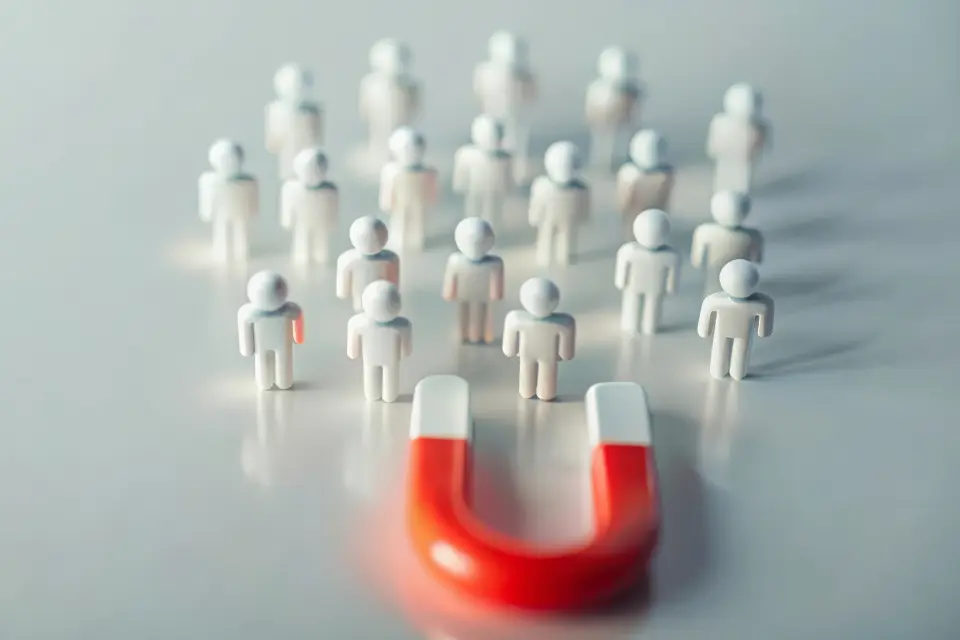 Roter Magnet zieht kleine Figuren an – Symbol für Wahlkampfstrategien und Wählergewinnung bei der Betriebsratswahl. Roter Magnet zieht kleine Figuren an – Symbol für Wahlkampfstrategien und Wählergewinnung bei der Betriebsratswahl.