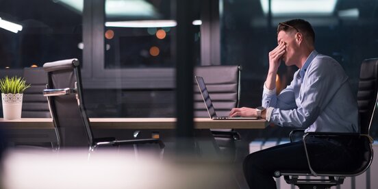 Ein Mann sitzt vor einem Laptop und arbeitet