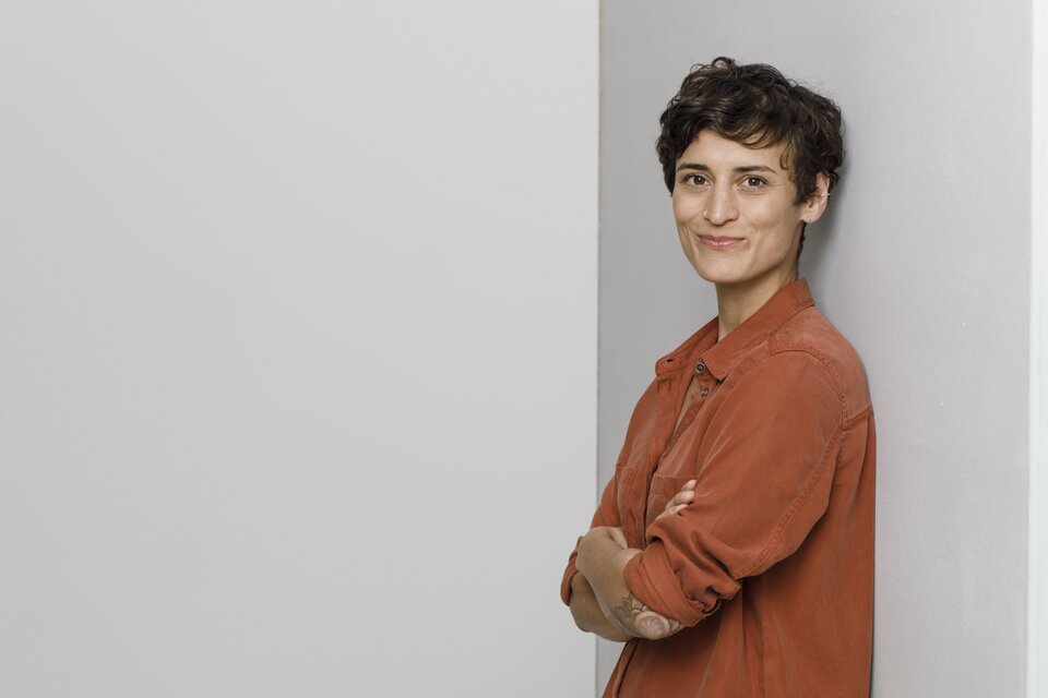 Eine Frau steht vor einer grauen Wand