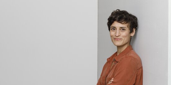 Eine Frau steht vor einer grauen Wand Eine Frau steht vor einer grauen Wand