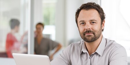 Ein Mann sitzt vor einem Laptop Ein Mann sitzt vor einem Laptop