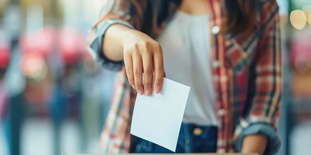 Frau wirft ihren Stimmzettel in eine Wahlurne Frau wirft ihren Stimmzettel in eine Wahlurne