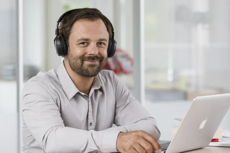 Person sitzt vor einem Laptop und verrichtet Bildschirmarbeit Person sitzt vor einem Laptop und verrichtet Bildschirmarbeit