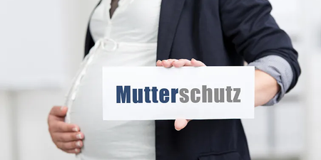 Person ist schwanger und hat ein Plakat in der Hand mit dem Aufdruck Mutterschutz Person ist schwanger und hat ein Plakat in der Hand mit dem Aufdruck Mutterschutz