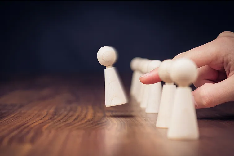Spielfigur wird mit dem Finger weggeschnipst, dies spiegelt die Kündigung wieder Spielfigur wird mit dem Finger weggeschnipst, dies spiegelt die Kündigung wieder