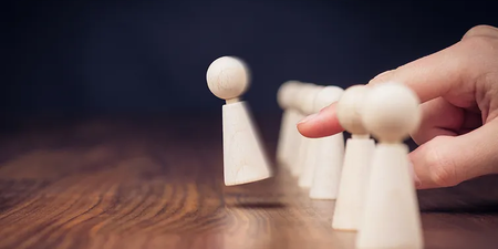 Spielfigur wird mit dem Finger weggeschnipst, dies spiegelt die Kündigung wieder Spielfigur wird mit dem Finger weggeschnipst, dies spiegelt die Kündigung wieder