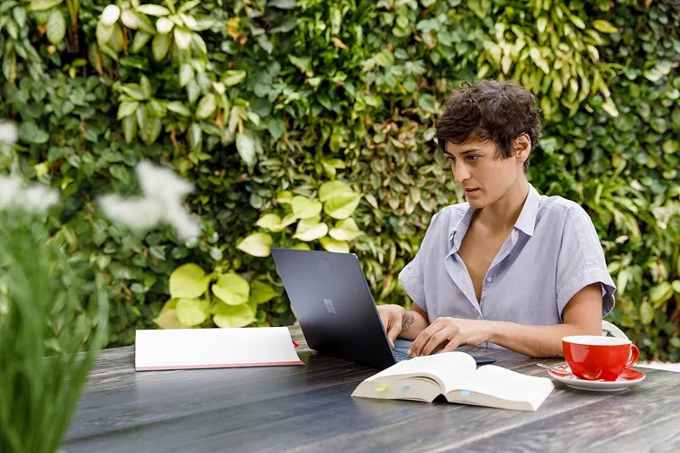 Person informiert sich draußen um grünen an ihrem Laptop über den Gleichbehandlungsgrundsatz Person informiert sich draußen um grünen an ihrem Laptop über den Gleichbehandlungsgrundsatz