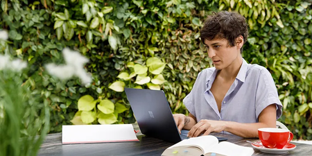 Person informiert sich draußen um grünen an ihrem Laptop über den Gleichbehandlungsgrundsatz