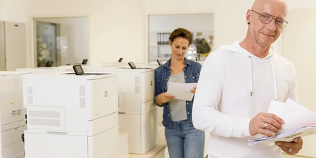 Person entnimmt dem Drucker ein Blatt Papier Person entnimmt dem Drucker ein Blatt Papier
