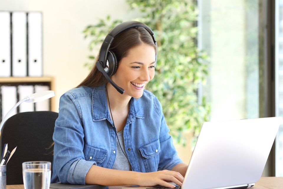 Eine Frau sitzt vor einem Laptop und arbeitet
